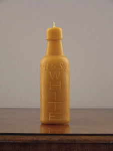 beeswax candle in the shape of an antique bottle