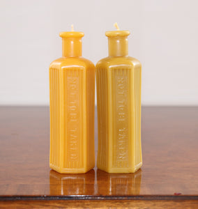 two beeswax candles in the shape of an old poison bottle